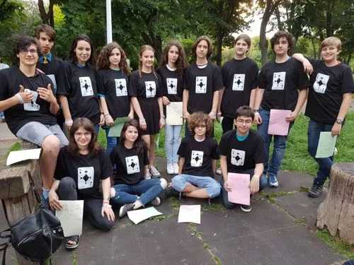 Grup de elevi ai Școlii 97, în tricouri negre cu emblema concursului, într-un parc